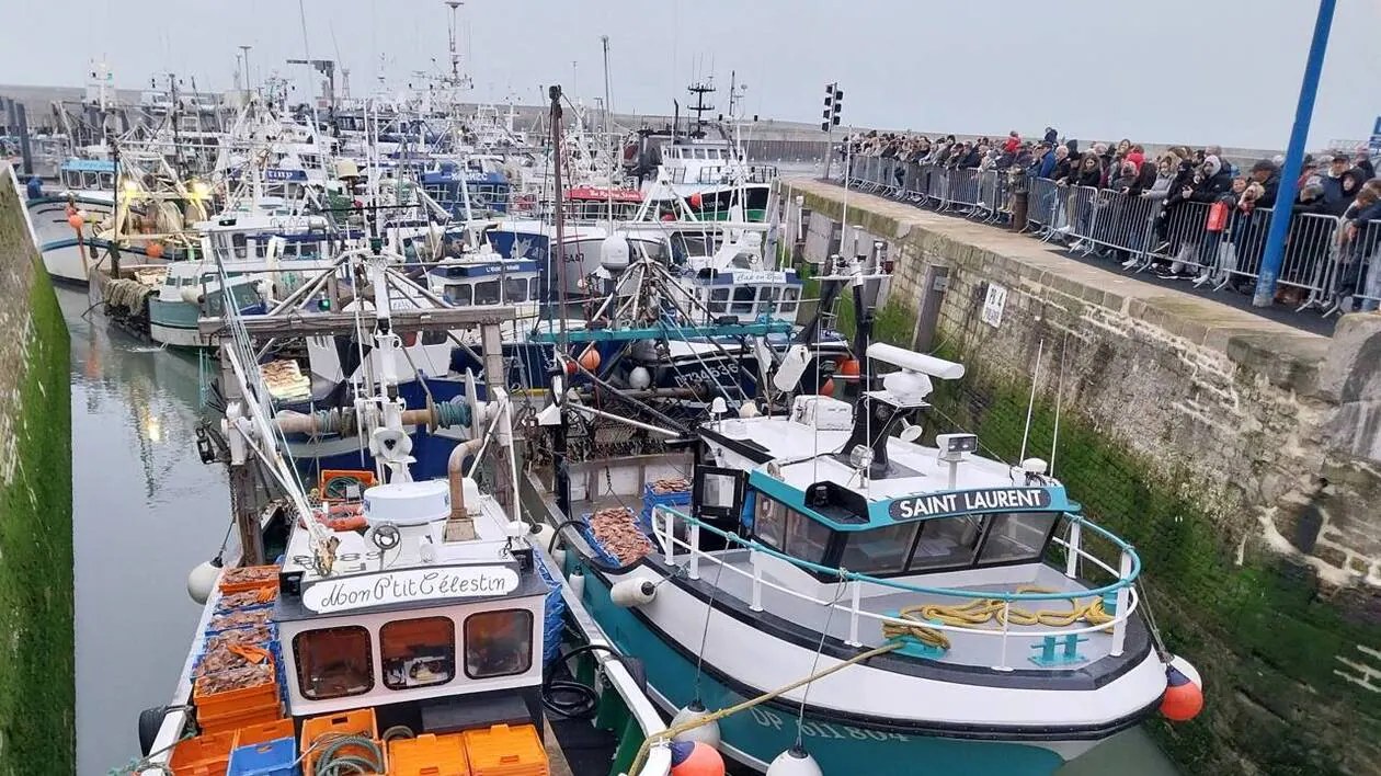 Les quais du port de pêche de Port en Bessin en Normandie, avec les bateaux amarrés au pied des falaises