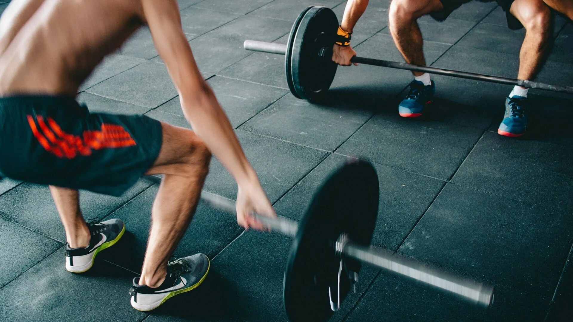 Cours collectif dans un studio de barre fitness en franchise, élèves alignés le long d'une barre murale